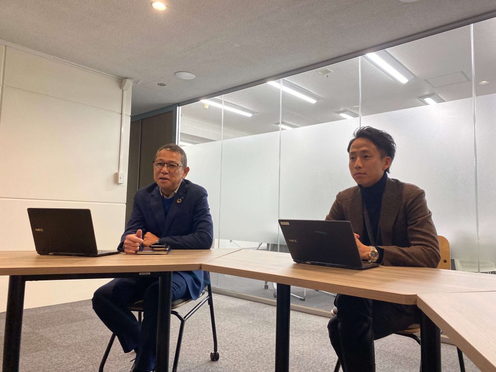 株式会社メコム様インタビュー風景。スマート公共ラボは、LINE公式アカウントを活用し自治体業務のDXを実現できるサービス。広報のセグメント発信から、AIチャットボットを活用しごみ捨て情報など様々なお問合せをLINEで対応でき、また、コロナワクチン予約システムなどオンラインで各種申請、予約や、住民票のコピーなど決済まで完結できる電子申請など様々な自治体業務をデジタル化することができます。